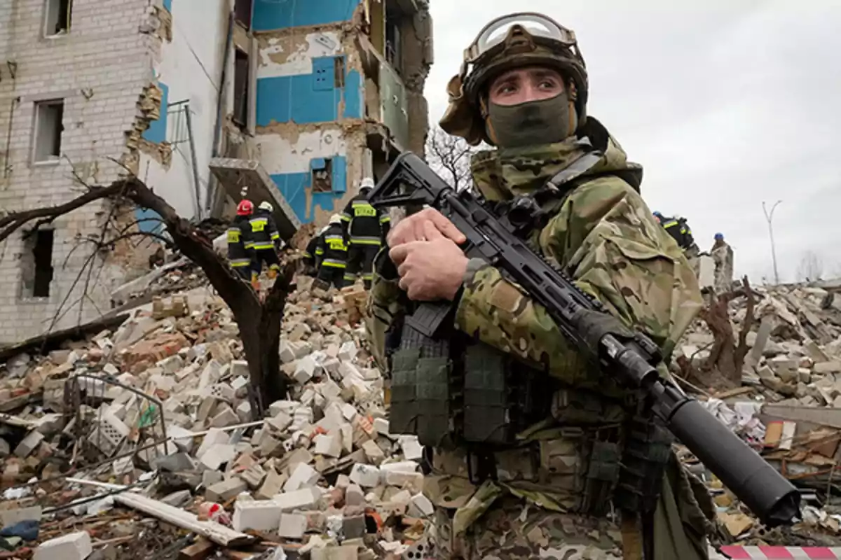 Soldier in camouflage uniform with an assault rifle standing among the rubble of a destroyed building while several rescuers search the area in the background. Soldier in camouflage uniform with an assault rifle standing among the rubble of a destroyed building while several rescuers search the area in the background.