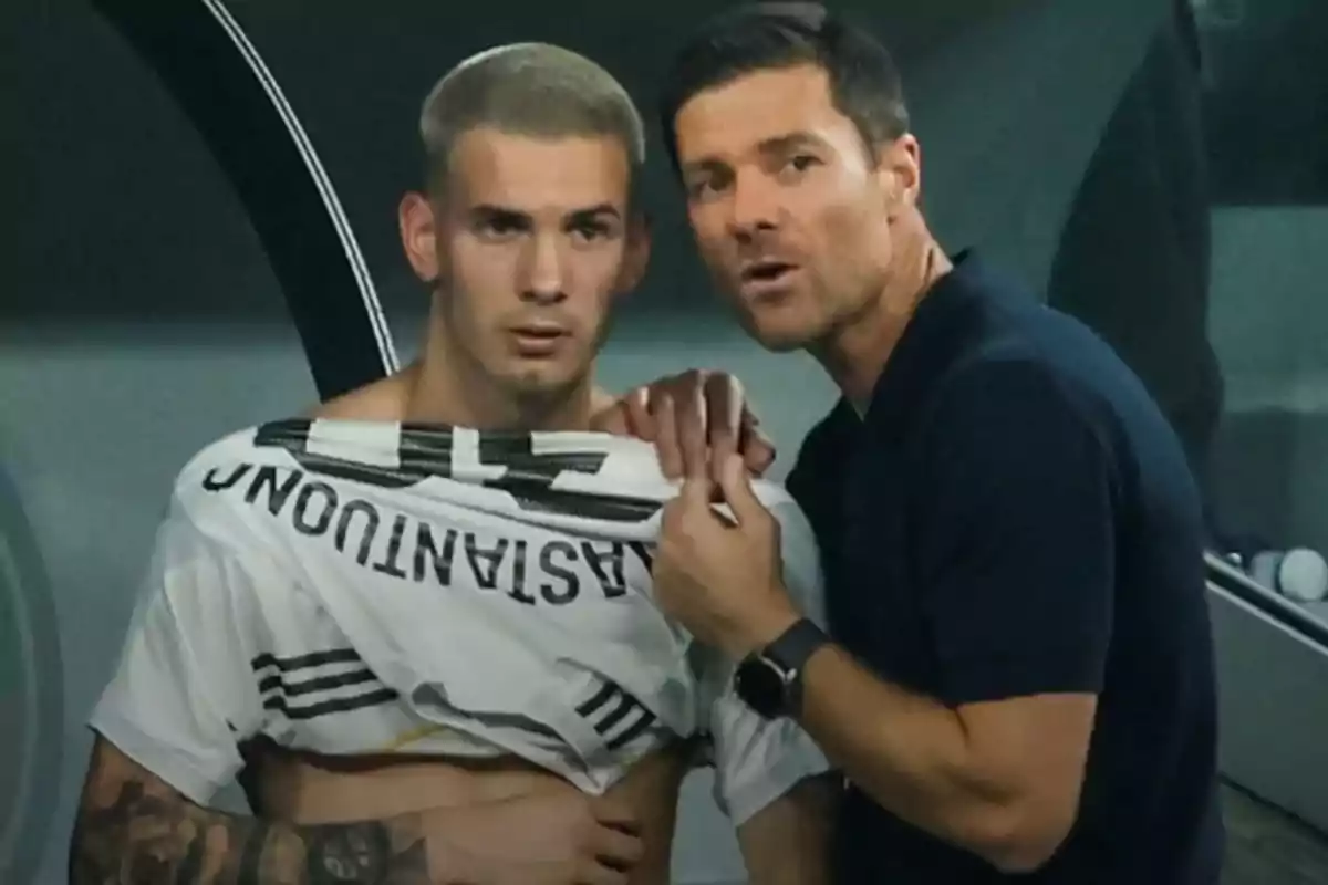 Coach gives instructions to a player who is lifting his jersey during a soccer match. Coach gives instructions to a player who is lifting his jersey during a soccer match.
