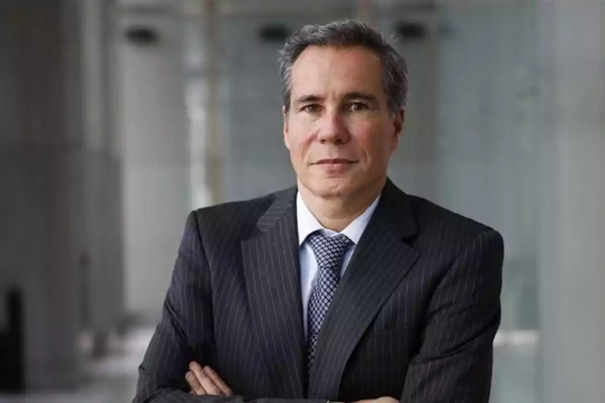 Gray-haired man in a dark suit and tie posing with his arms crossed in a professional setting Gray-haired man in a dark suit and tie posing with his arms crossed in a professional setting