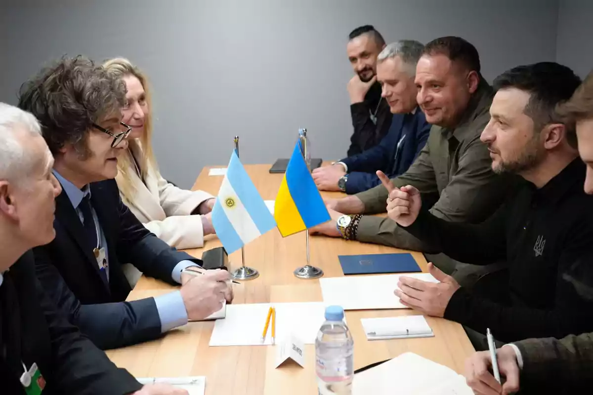 Reunión entre delegaciones de Argentina y Ucrania en una mesa de madera con banderas de ambos países al centro Reunión entre delegaciones de Argentina y Ucrania en una mesa de madera con banderas de ambos países al centro