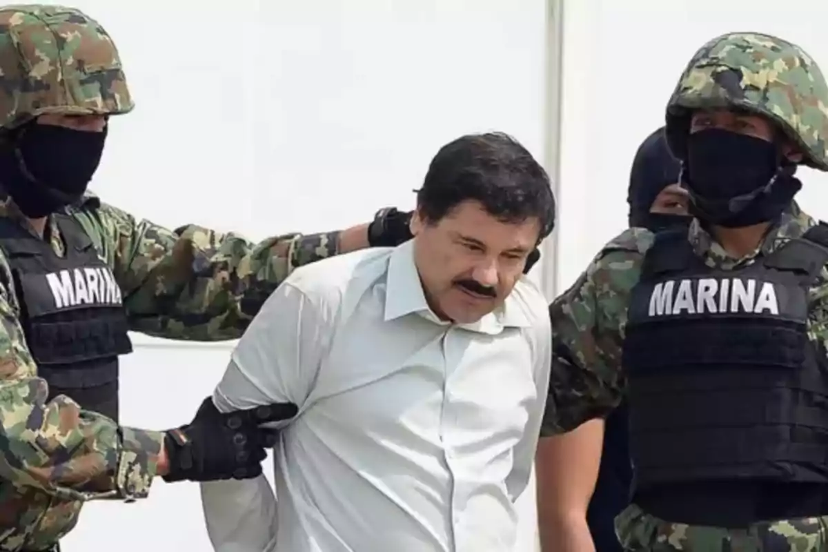 Man escorted by two navy personnel dressed in camouflage uniforms and bulletproof vests Man escorted by two navy personnel dressed in camouflage uniforms and bulletproof vests