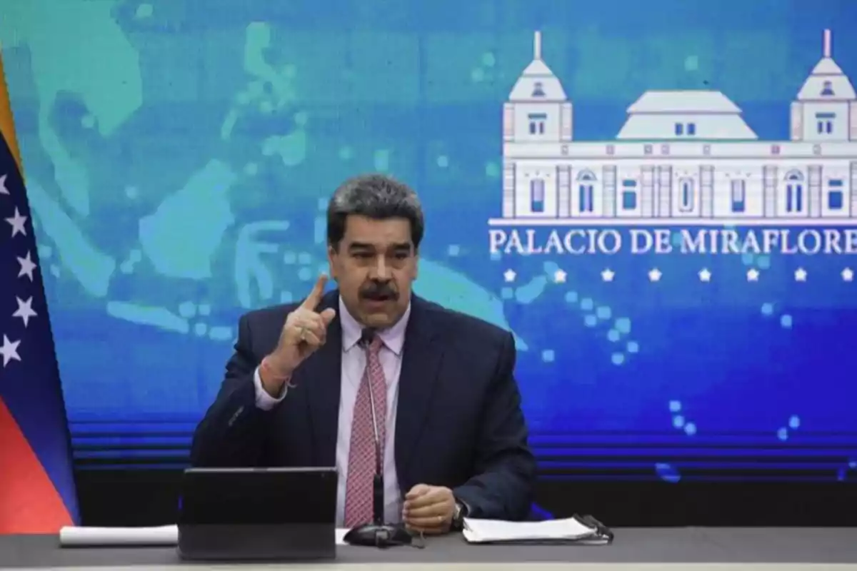 Man in a suit speaking at a conference with a blue background and the text Palacio de Miraflores Man in a suit speaking at a conference with a blue background and the text Palacio de Miraflores