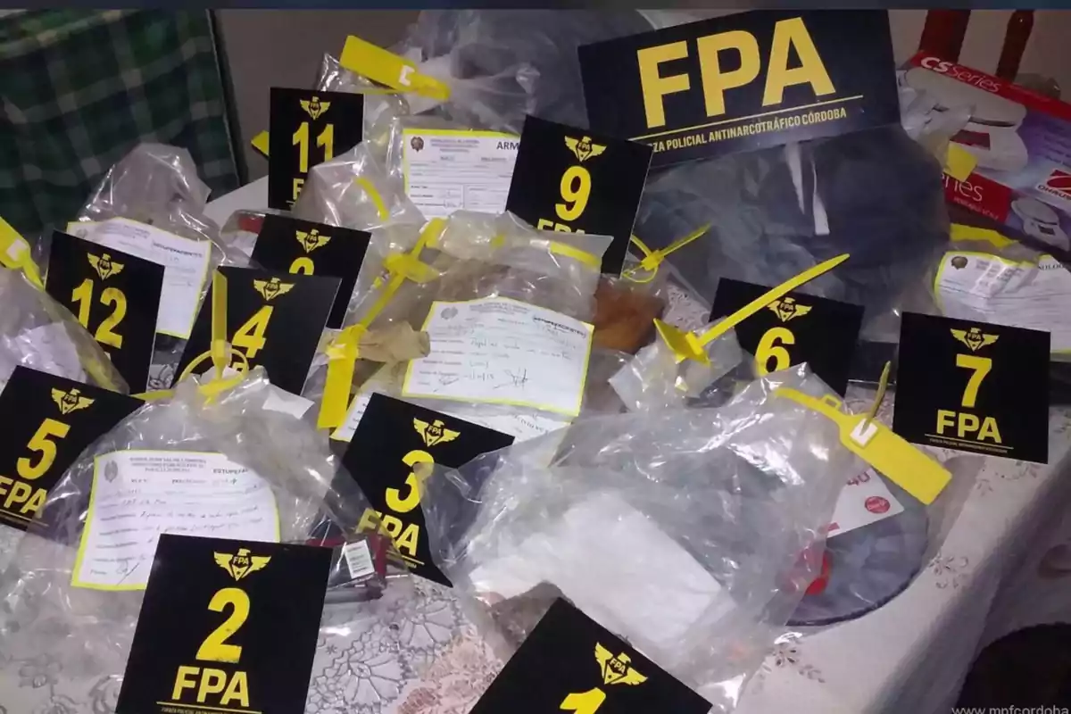 Numbered and bagged evidence on a table with labels from the Córdoba Anti-Narcotics Police Force