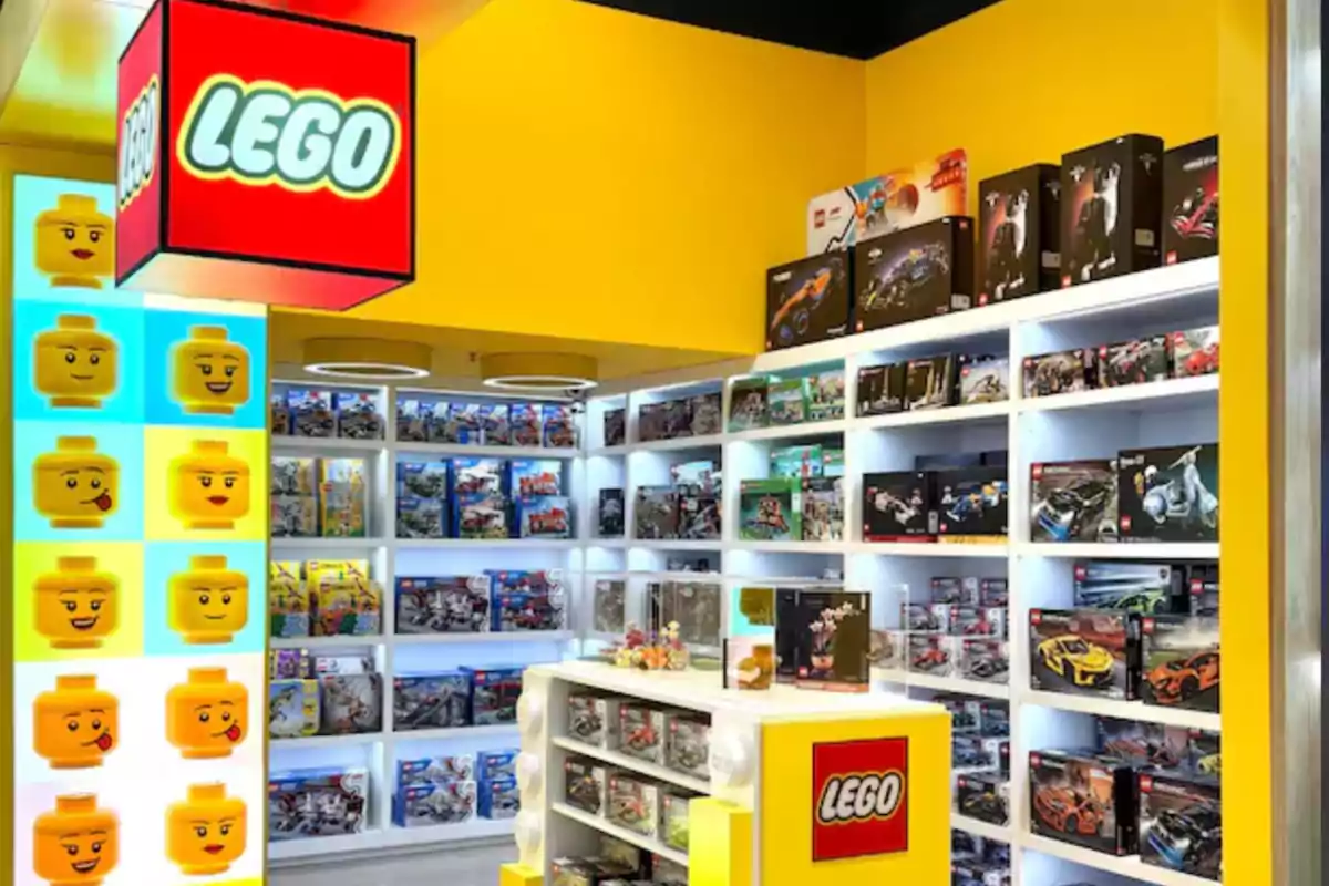 Tienda de LEGO con estanterías llenas de cajas de sets y decoración colorida con cabezas de figuras y logotipos de la marca Tienda de LEGO con estanterías llenas de cajas de sets y decoración colorida con cabezas de figuras y logotipos de la marca