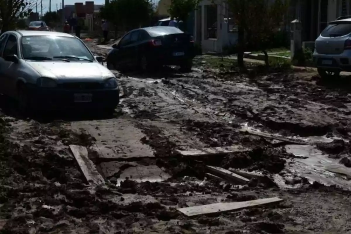 Dirt road in poor condition with lots of mud and several cars stuck. Dirt road in poor condition with lots of mud and several cars stuck.