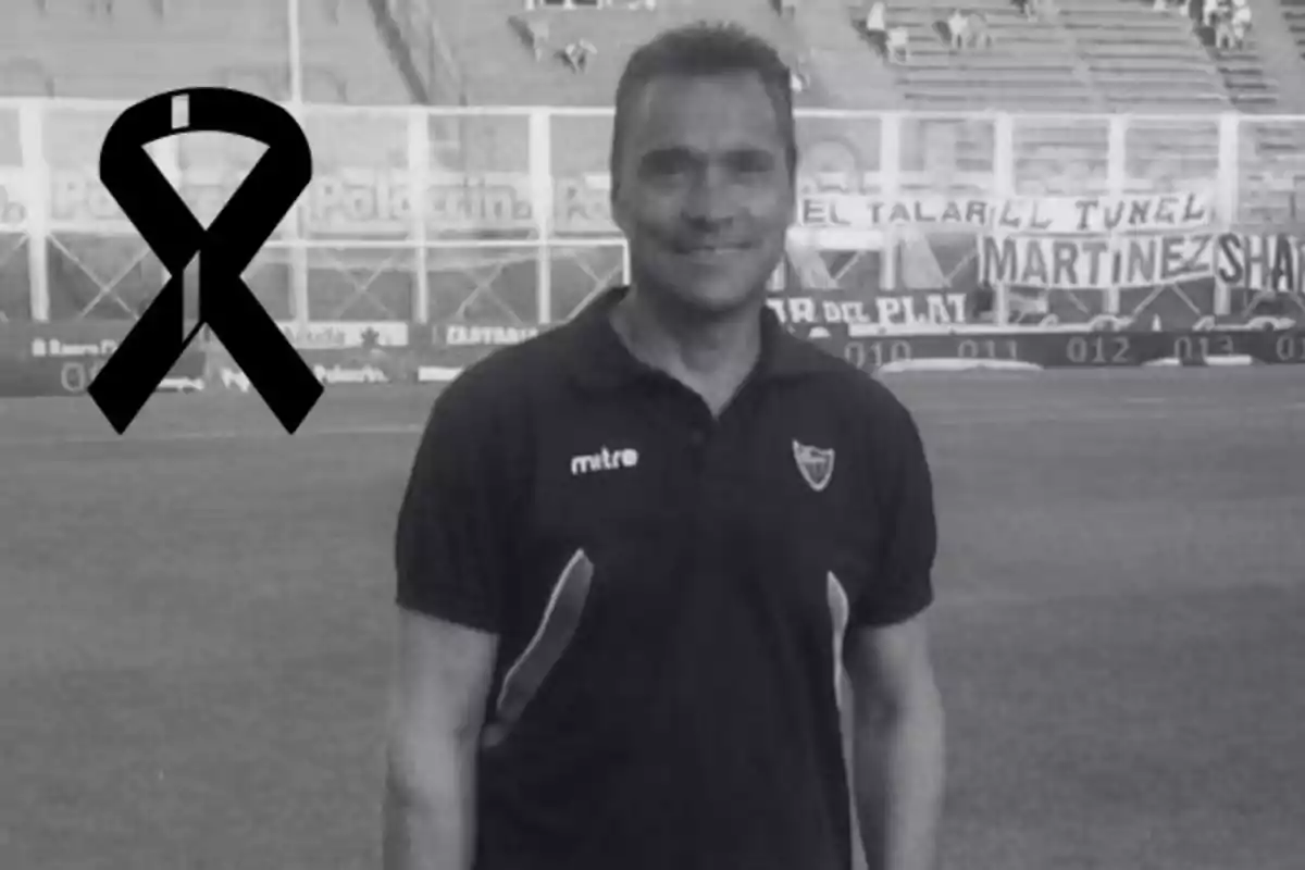 Smiling man on a soccer field with a black mourning ribbon in the corner of the image
