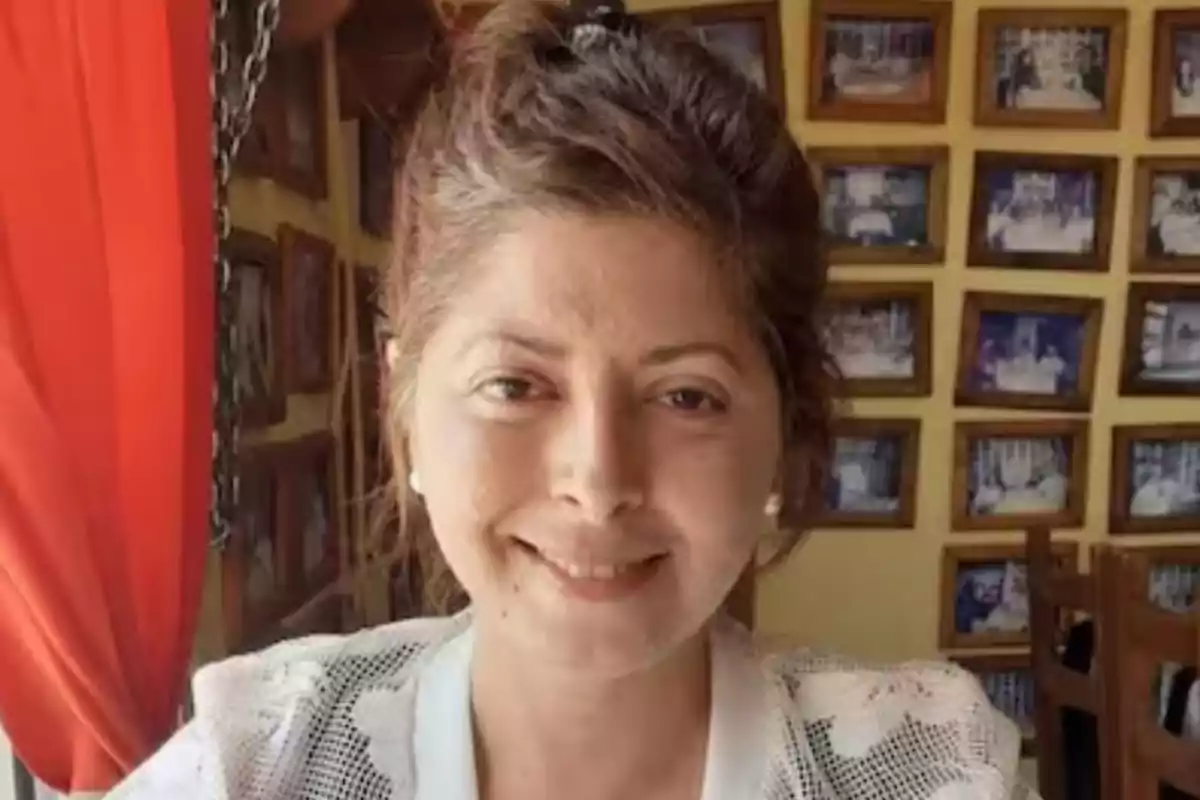 Smiling woman with her hair up sitting in a restaurant with walls decorated with many framed photos Smiling woman with her hair up sitting in a restaurant with walls decorated with many framed photos