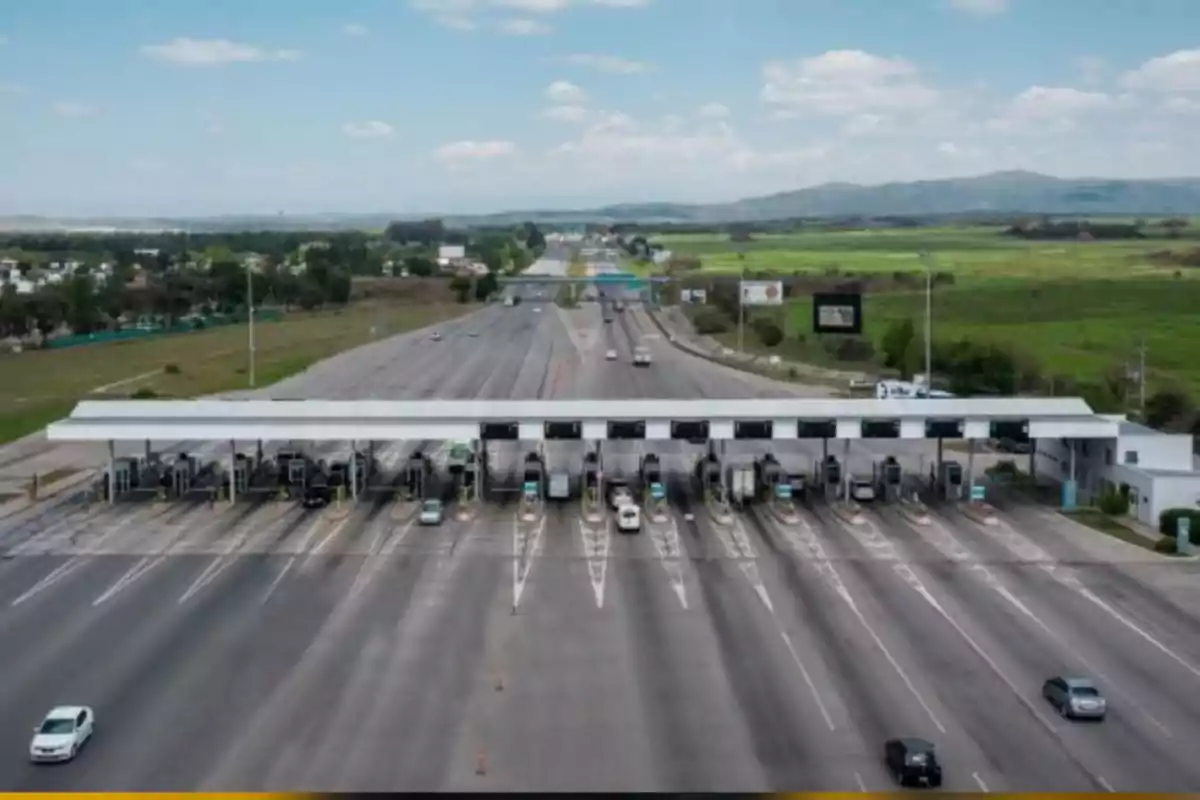 Toll booth on a highway with multiple lanes and vehicles passing by, surrounded by green areas and mountains in the background Toll booth on a highway with multiple lanes and vehicles passing by, surrounded by green areas and mountains in the background