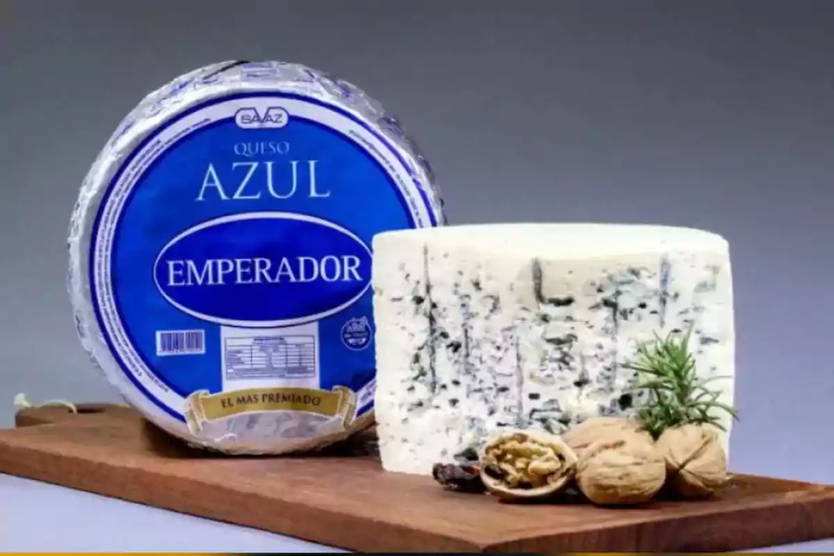 Queso azul Emperador sobre una tabla de madera acompañado de nueces y una ramita de romero Queso azul Emperador sobre una tabla de madera acompañado de nueces y una ramita de romero