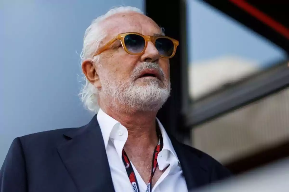 Older man with a white beard and sunglasses wearing a dark jacket and white jersey looking up Older man with a white beard and sunglasses wearing a dark jacket and white jersey looking up