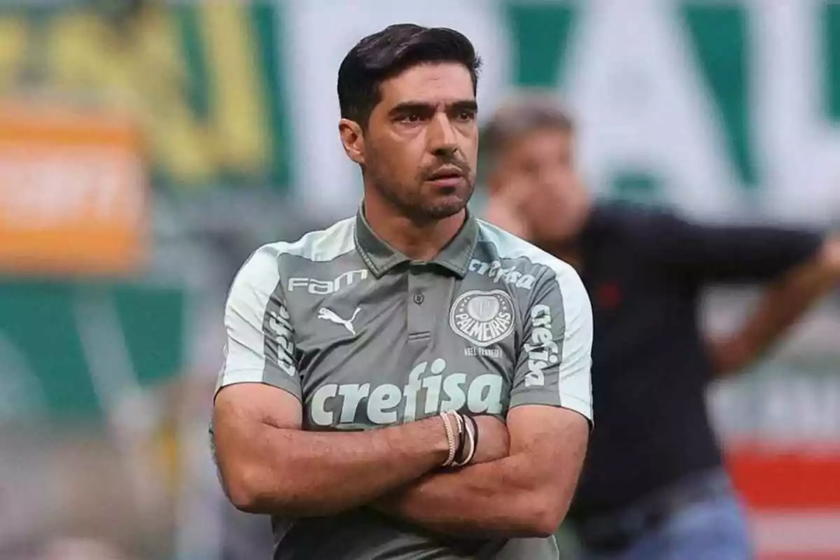 Palmeiras soccer coach with arms crossed and a serious expression during a match