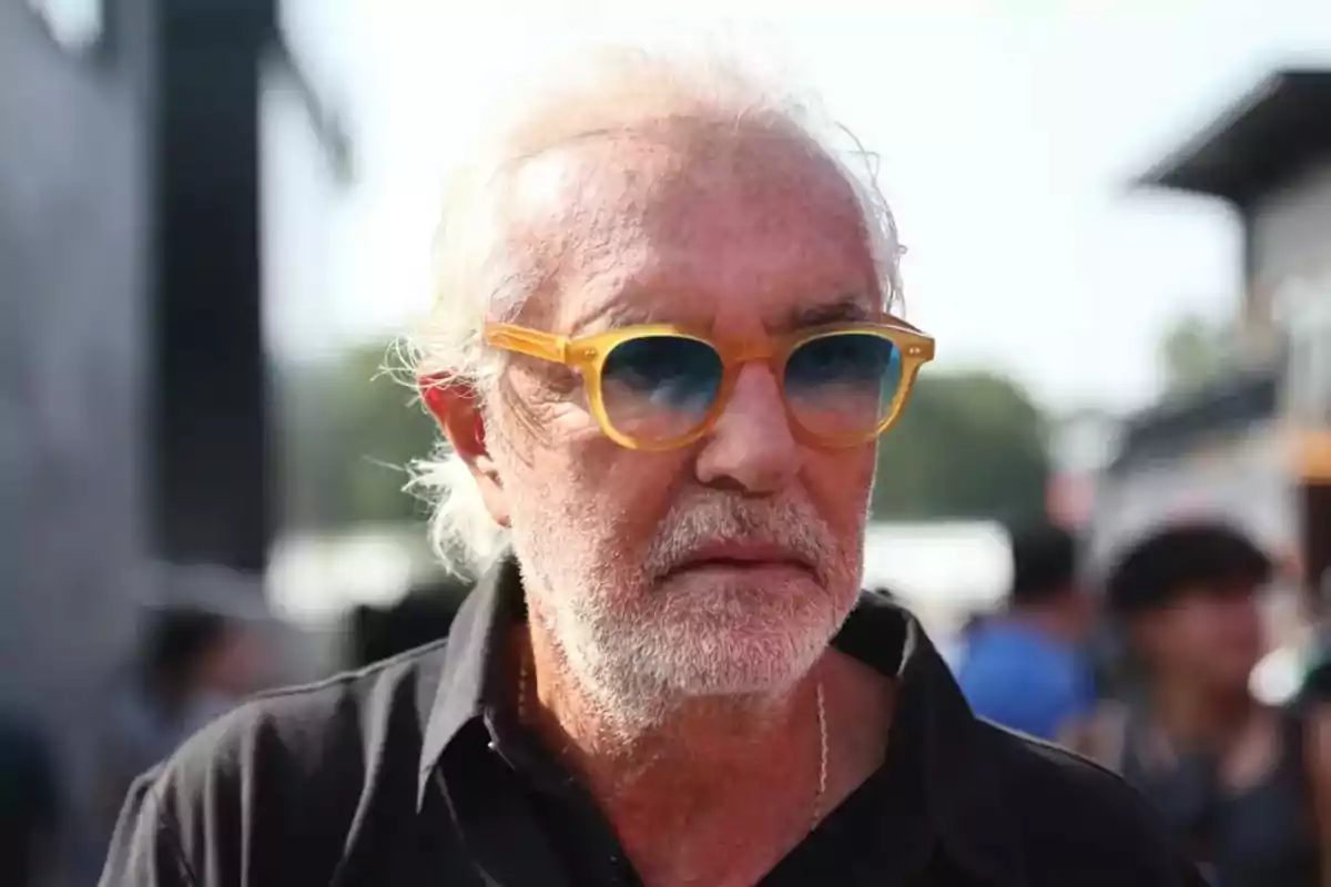 Older man with a beard and yellow sunglasses in an outdoor setting