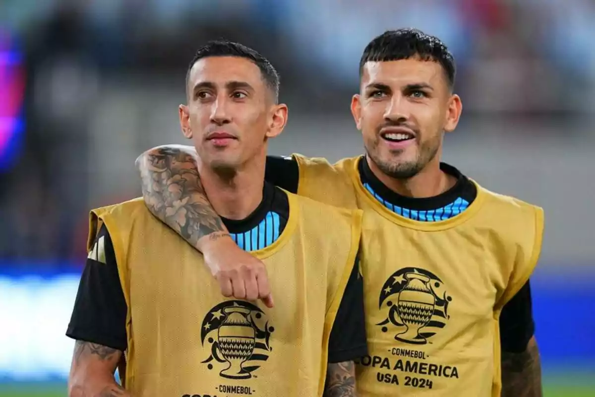 Two players wearing yellow bibs from Copa América USA 2024 pose together on the field, one of them with his arm around the other's shoulder. Two players wearing yellow bibs from Copa América USA 2024 pose together on the field, one of them with his arm around the other's shoulder.