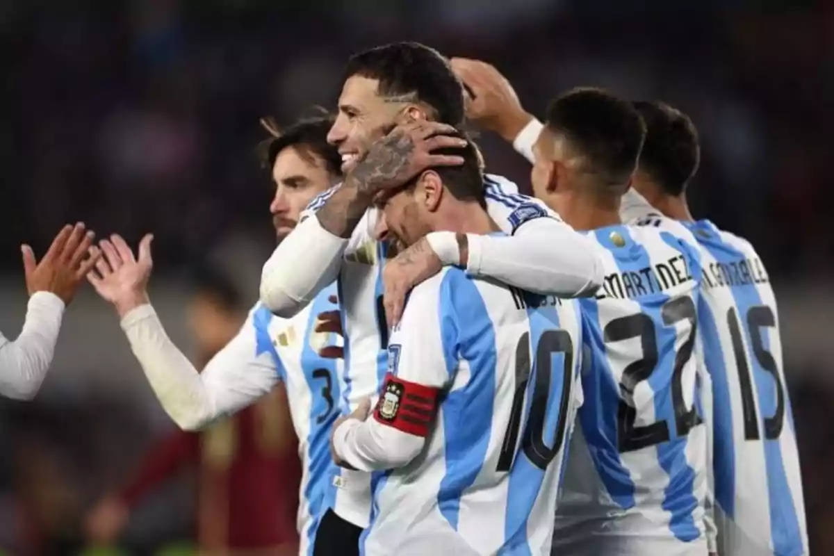 Jugadores de la selección argentina de fútbol celebran juntos en la cancha usando el uniforme celeste y blanco