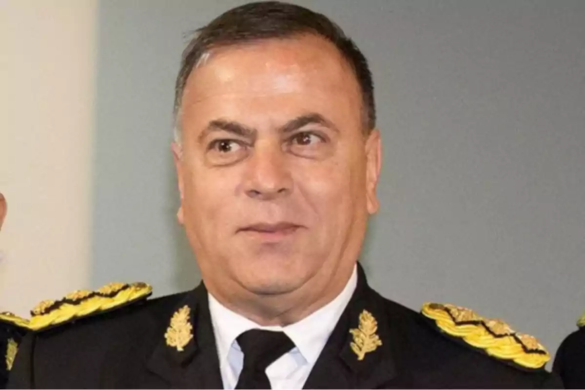 Hombre de mediana edad con uniforme militar oscuro y detalles dorados mirando hacia un lado