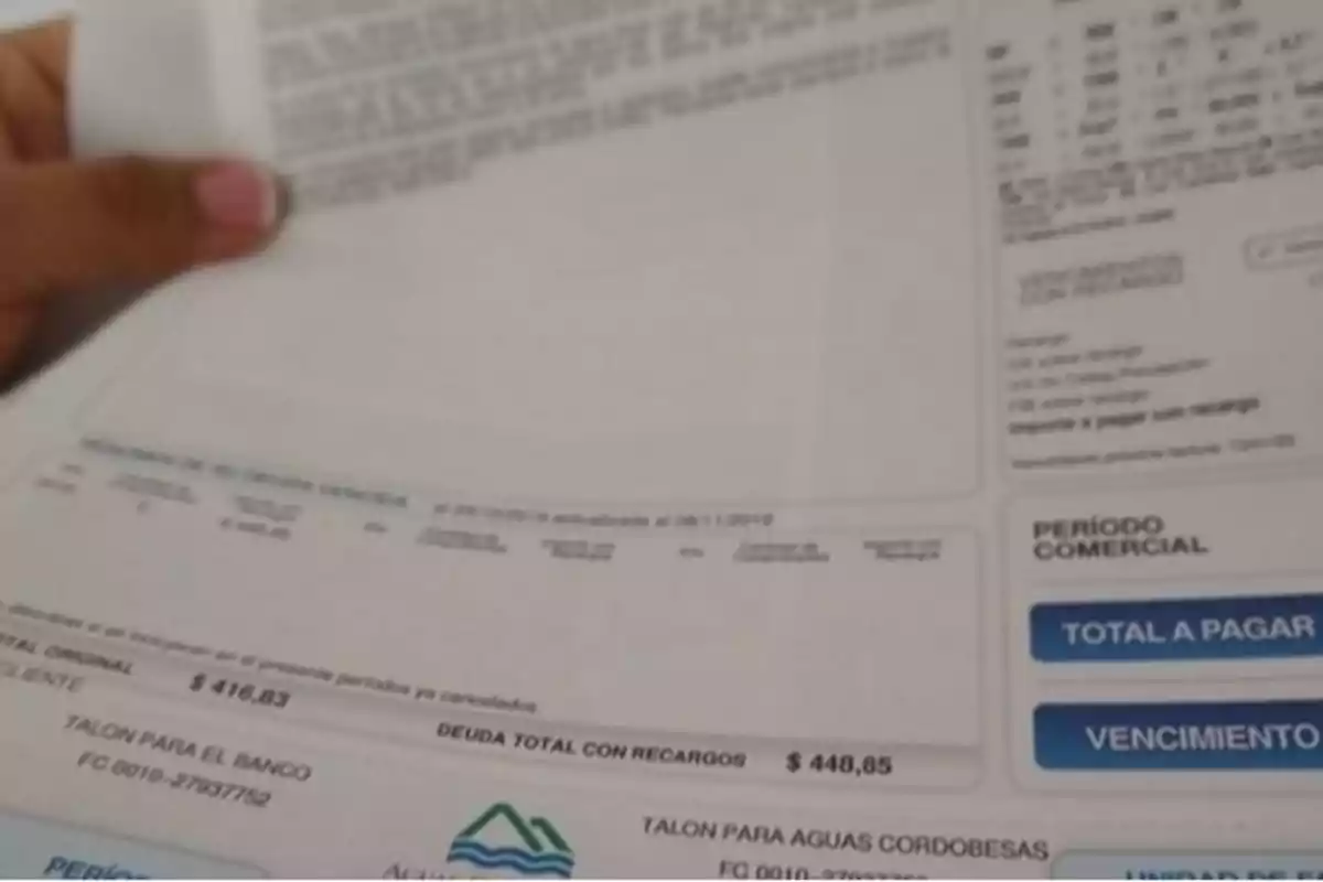 Person holding a utility bill with payment information and detailed amounts Person holding a utility bill with payment information and detailed amounts