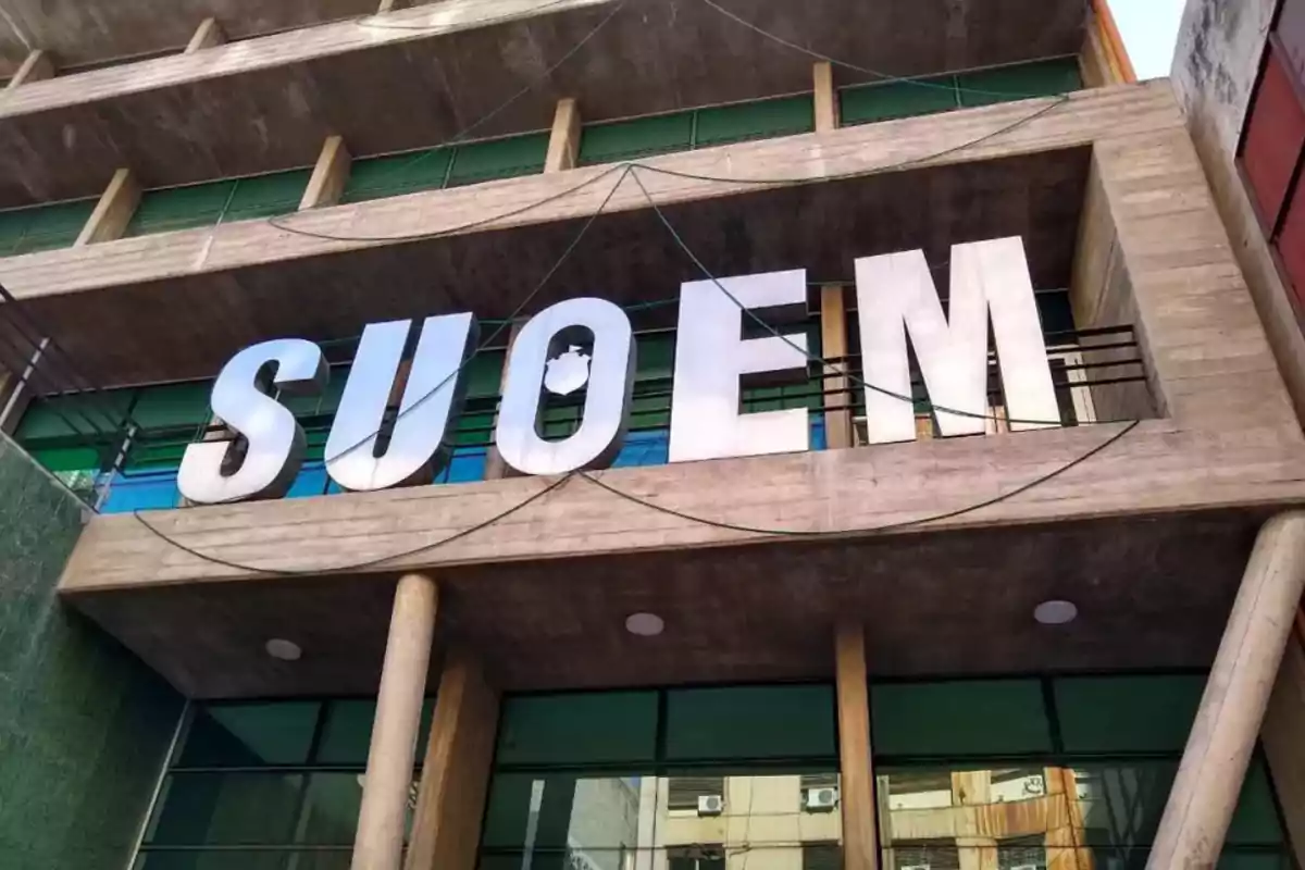 Facade of a building with large white letters spelling the word SUOEM