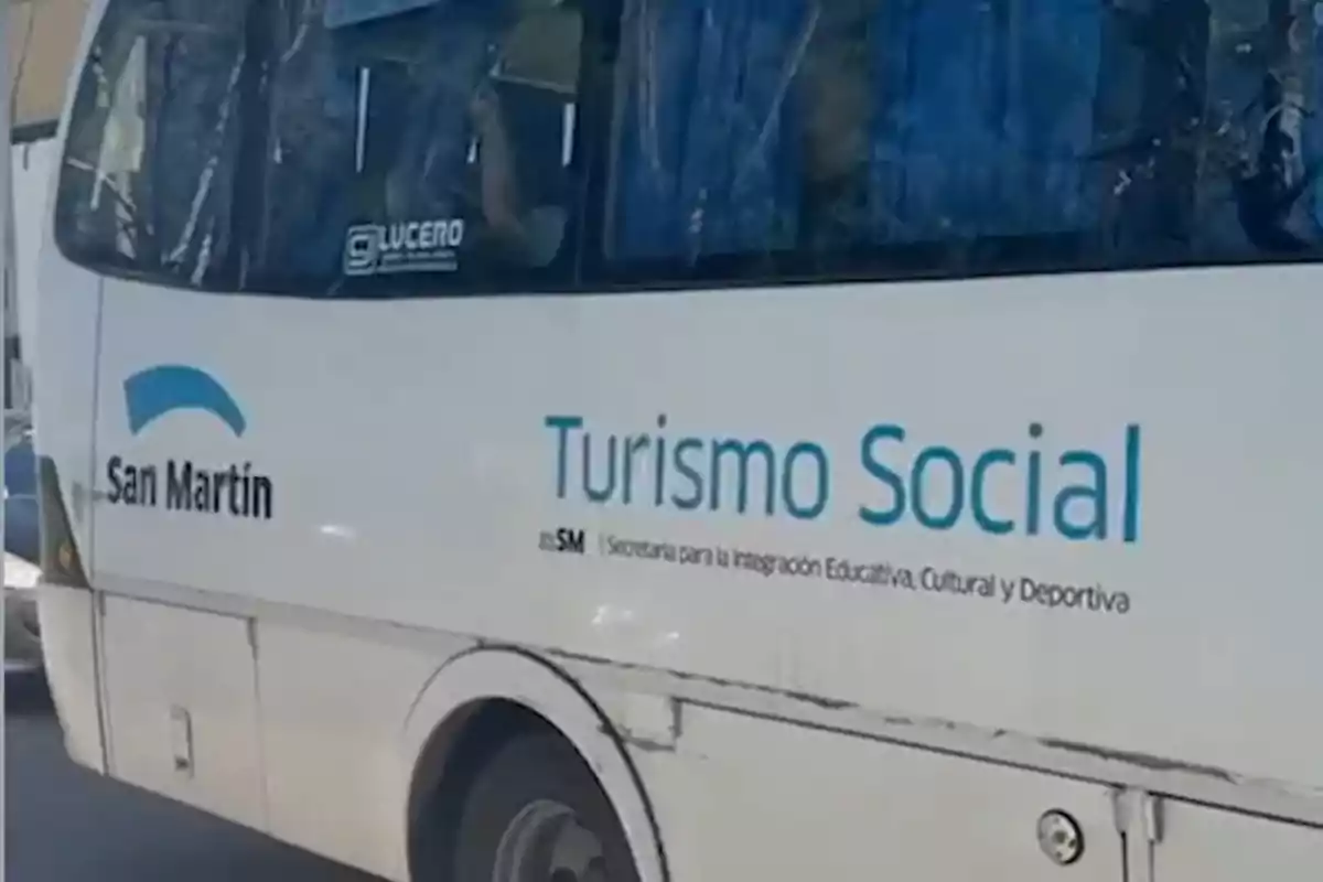 Un autobús blanco con el logo de San Martín y la leyenda Turismo Social en el costado