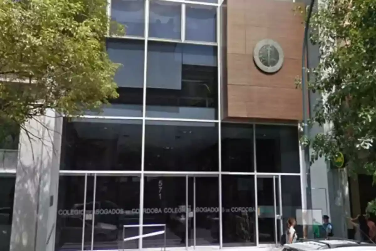Facade of a modern building with glass windows and a sign that reads Córdoba Bar Association