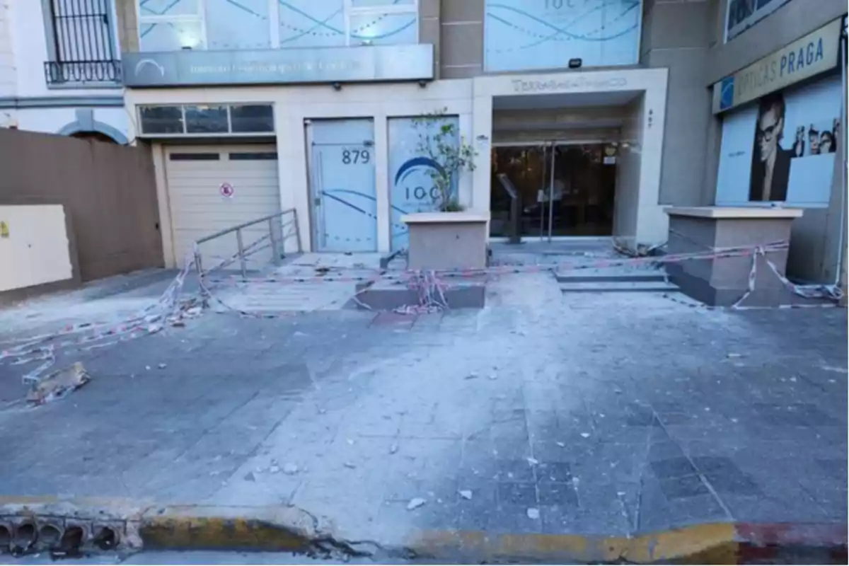 Building entrance with caution tape and debris on the sidewalk Building entrance with caution tape and debris on the sidewalk