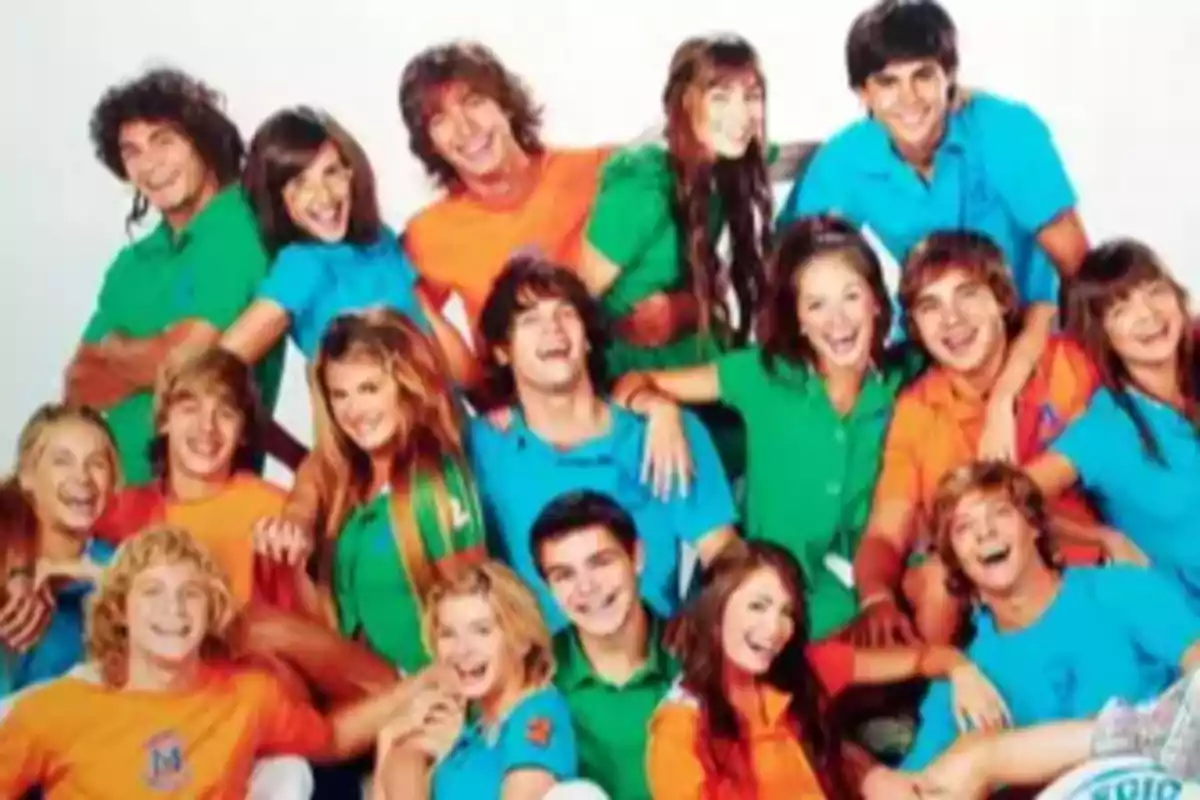 Grupo de jóvenes sonrientes posando juntos con camisetas de colores brillantes