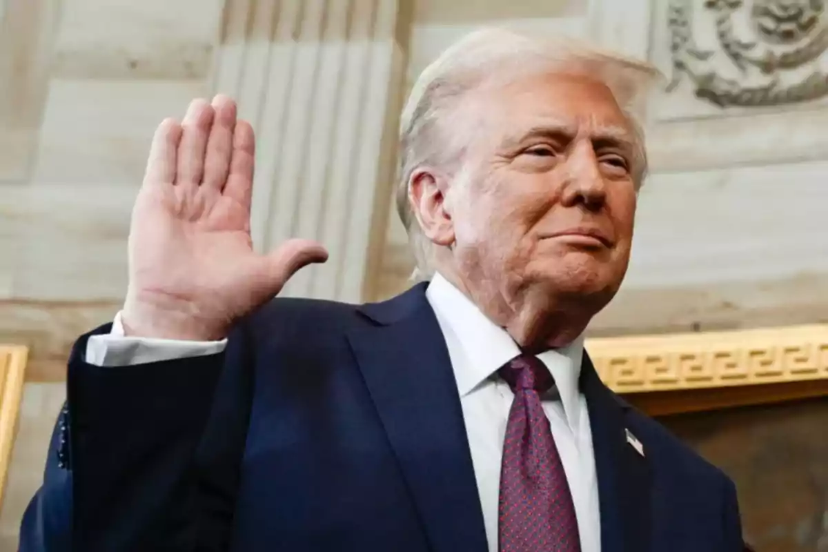 Hombre de cabello rubio con traje azul y corbata roja levantando la mano derecha en señal de juramento dentro de un edificio elegante Hombre de cabello rubio con traje azul y corbata roja levantando la mano derecha en señal de juramento dentro de un edificio elegante