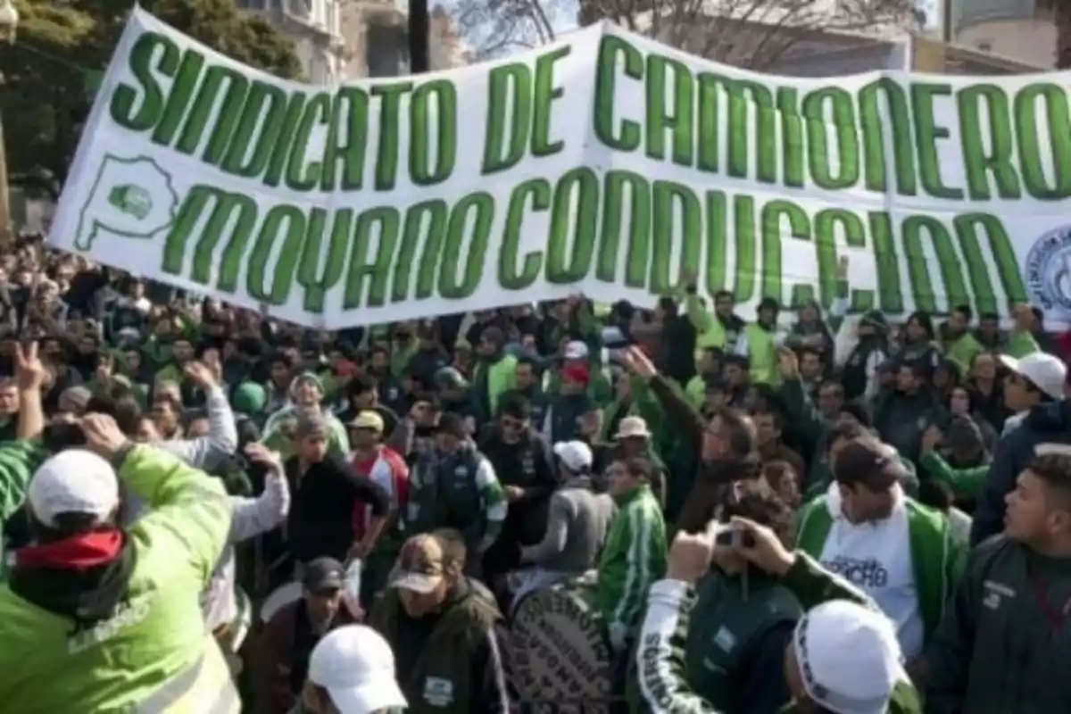 Manifestación de trabajadores con un gran cartel verde y blanco que dice Sindicato de Camioneros Moyano Conducción y muchas personas vestidas con ropa verde