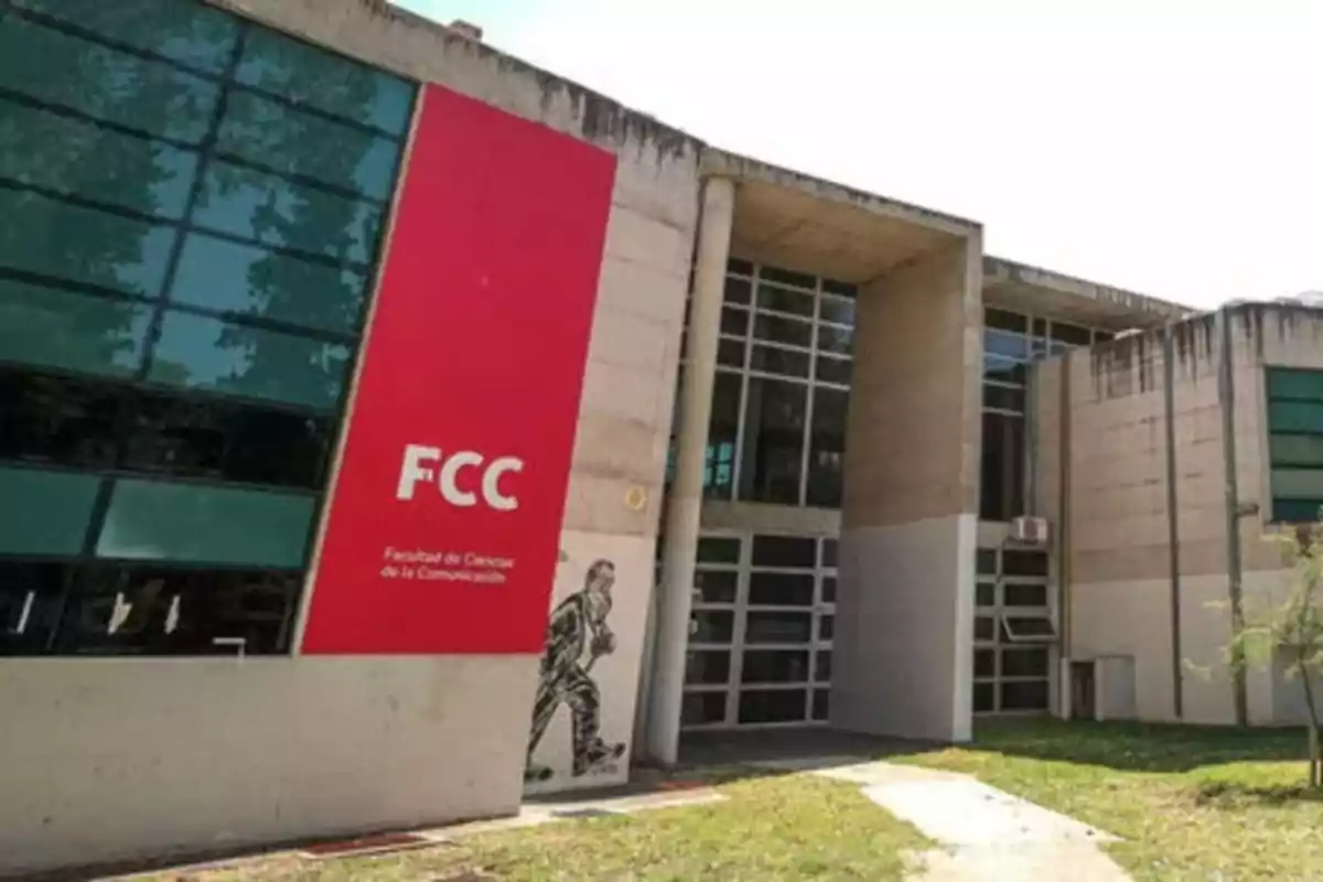 Modern building of the School of Communication Sciences with a large red sign and glass windows