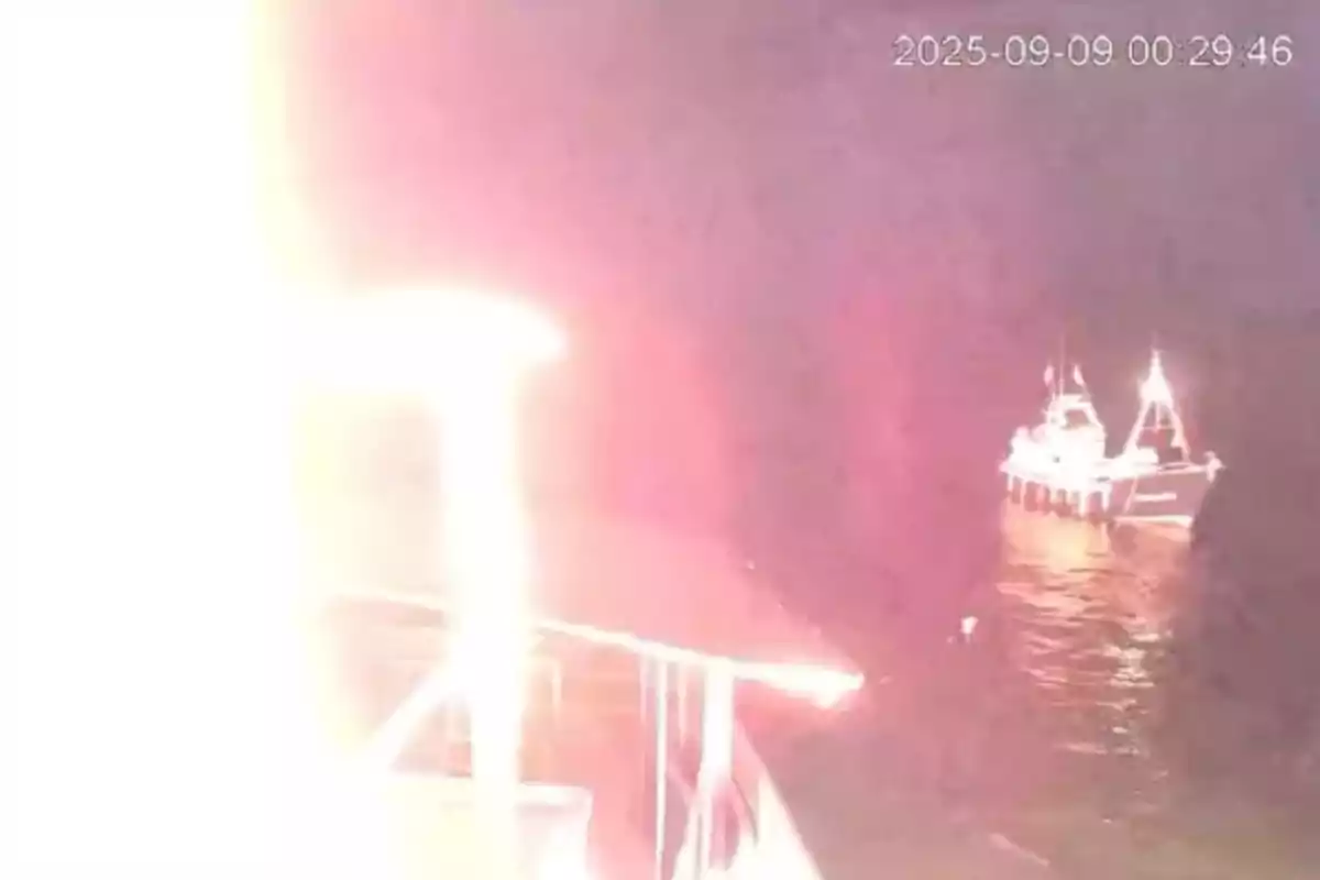 Un rayo impacta un barco en el mar durante la noche mientras otro barco se encuentra cerca iluminado por la luz del relámpago Un rayo impacta un barco en el mar durante la noche mientras otro barco se encuentra cerca iluminado por la luz del relámpago