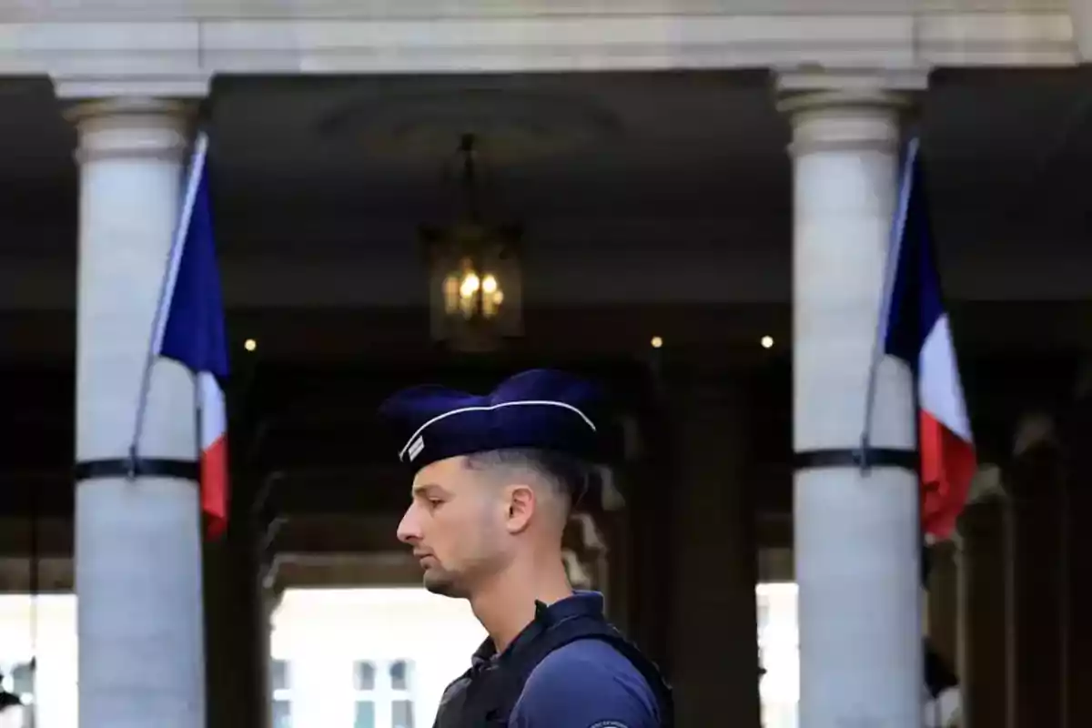 French police officer in profile wearing a uniform and cap, standing between columns with French flags in the background French police officer in profile wearing a uniform and cap, standing between columns with French flags in the background