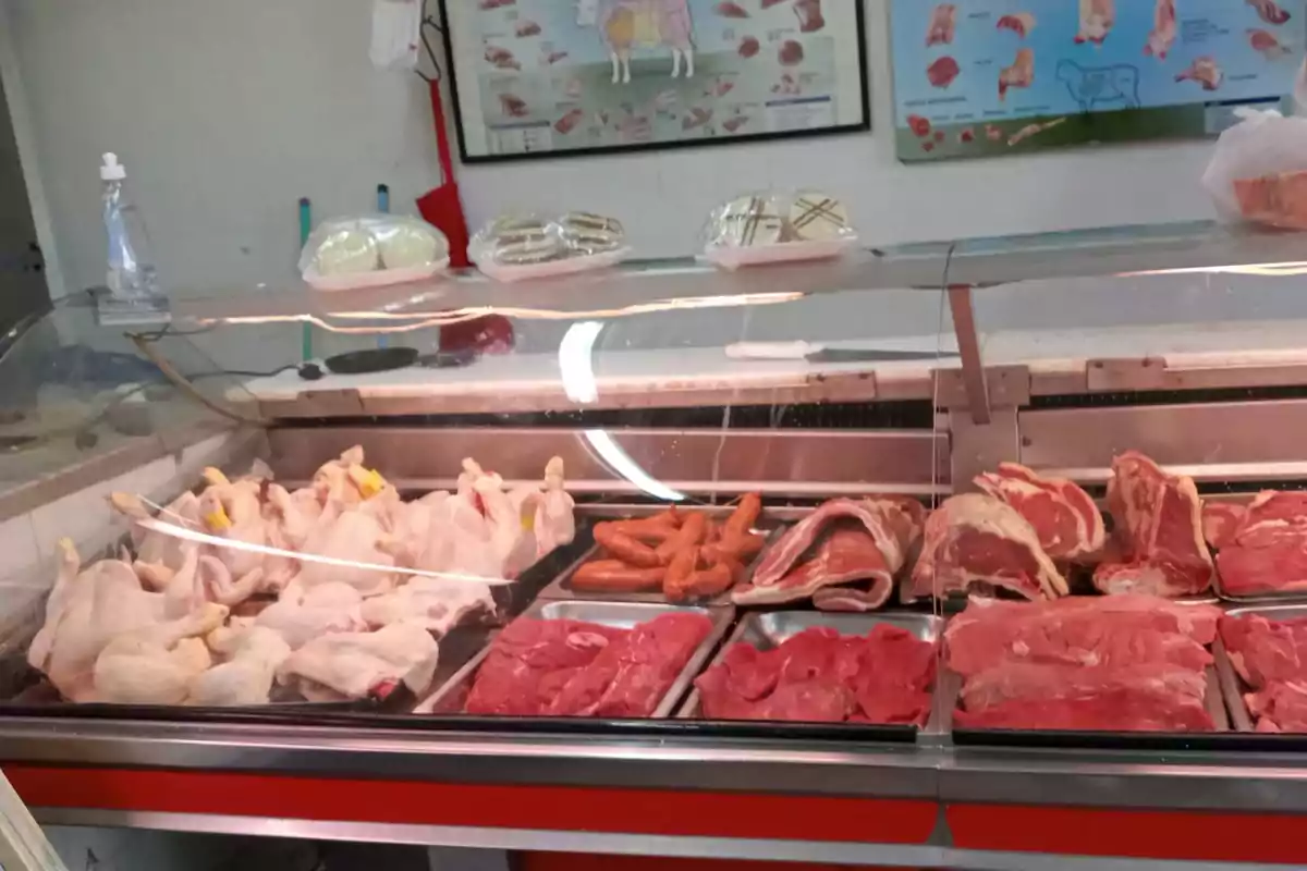 Butcher display case with whole chickens, sausages, beef and pork cuts, as well as some packaged products on the top. Butcher display case with whole chickens, sausages, beef and pork cuts, as well as some packaged products on the top.