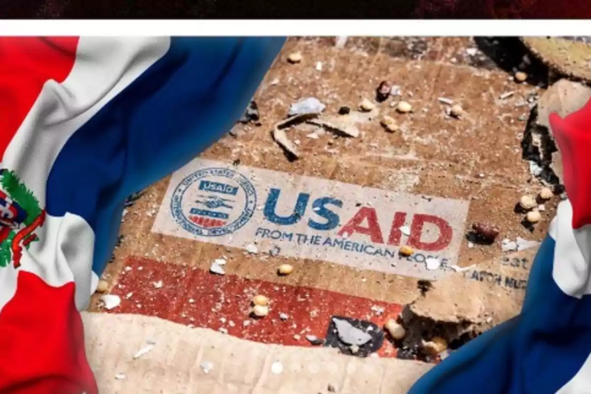 Caja de ayuda humanitaria de USAID sobre el suelo rodeada por dos banderas de República Dominicana