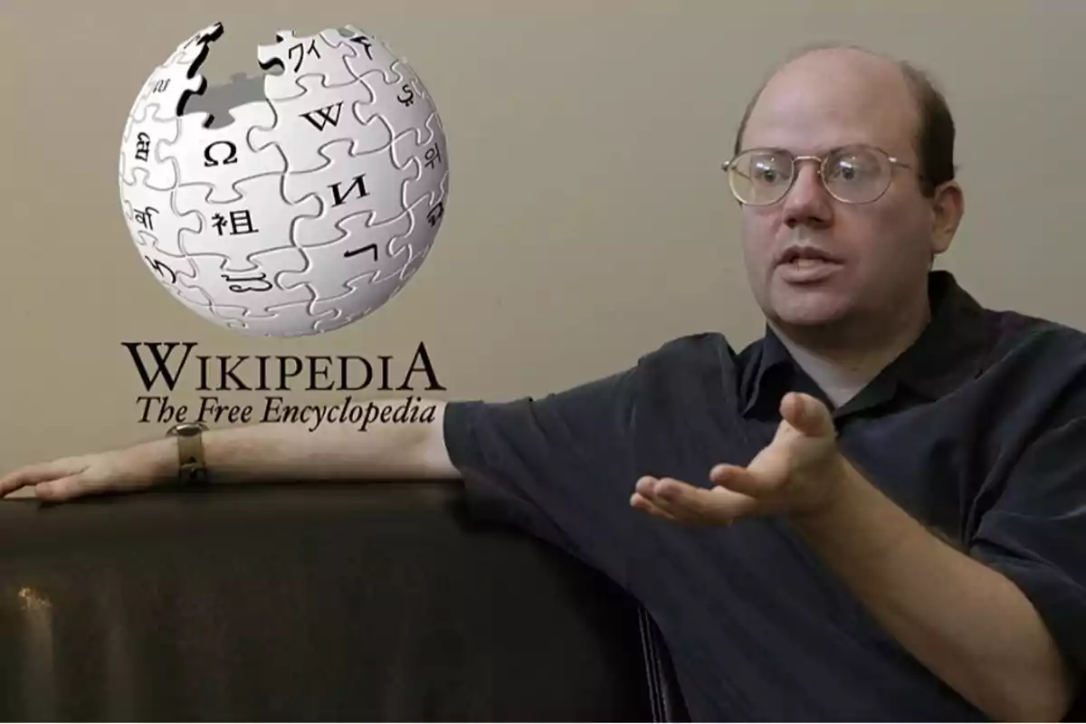 Hombre con gafas y camisa oscura sentado en un sofá gesticulando con la mano, junto al logo de Wikipedia y el texto The Free Encyclopedia Hombre con gafas y camisa oscura sentado en un sofá gesticulando con la mano, junto al logo de Wikipedia y el texto The Free Encyclopedia