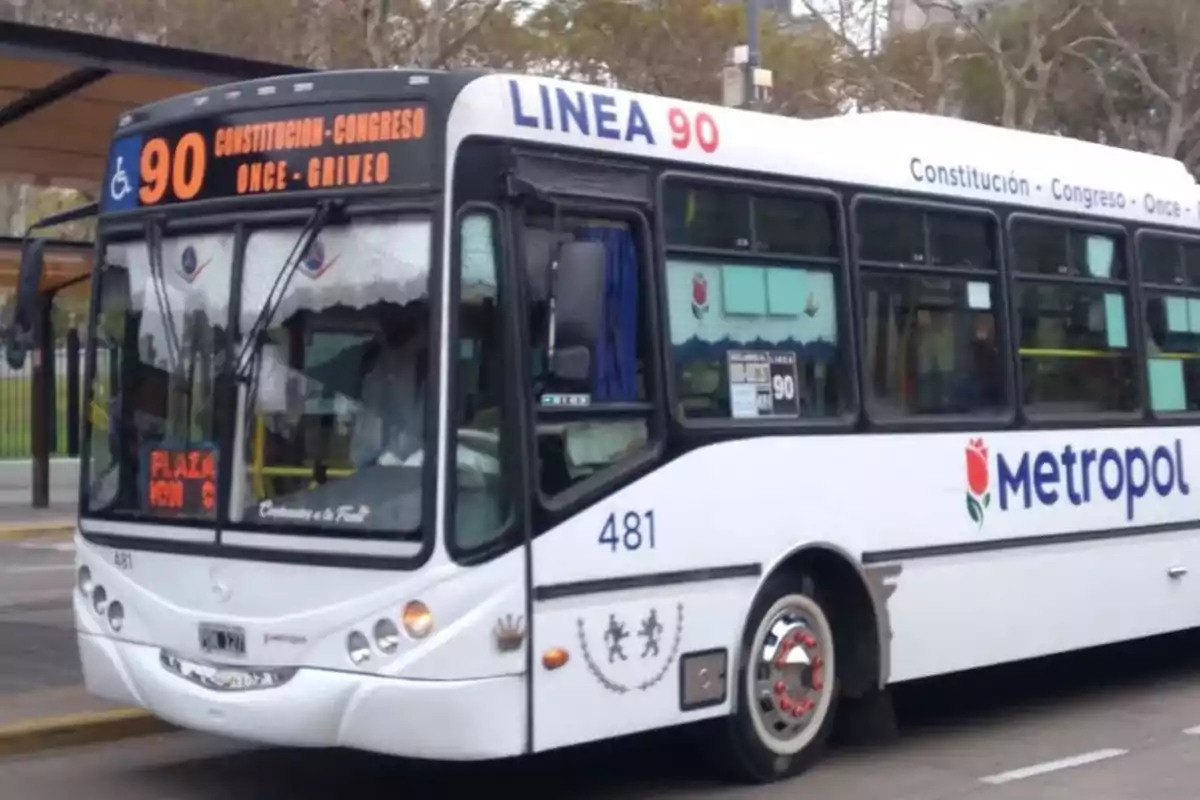 A white bus from line 90 of the Metropol company stopped at a bus stop in the city. A white bus from line 90 of the Metropol company stopped at a bus stop in the city.