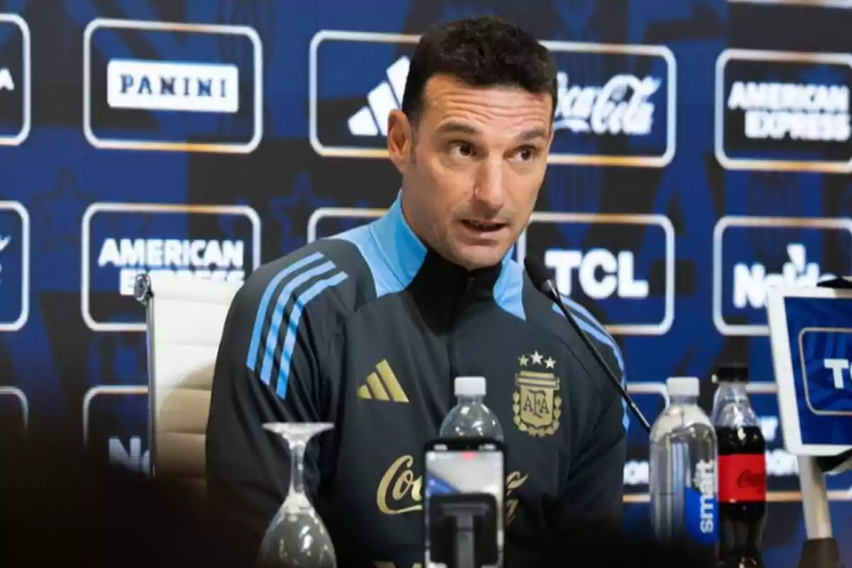 Entrenador de la selección argentina de fútbol hablando en una conferencia de prensa con micrófono y botellas de agua sobre la mesa Entrenador de la selección argentina de fútbol hablando en una conferencia de prensa con micrófono y botellas de agua sobre la mesa