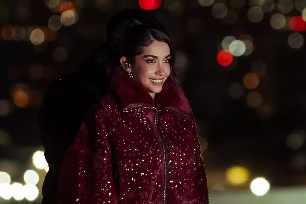 Smiling woman in a decorated red coat with a blurred lights background