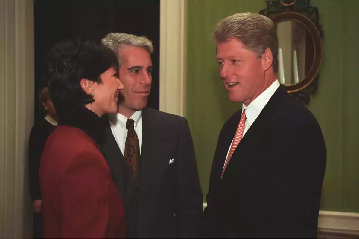 Three people dressed formally are talking in an elegant room with green walls and a round mirror in the background. Three people dressed formally are talking in an elegant room with green walls and a round mirror in the background.