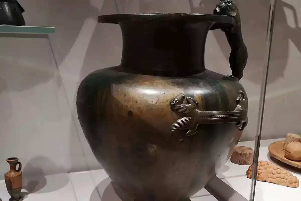 Ancient metal vase with handles decorated with animal figures displayed in a museum Ancient metal vase with handles decorated with animal figures displayed in a museum