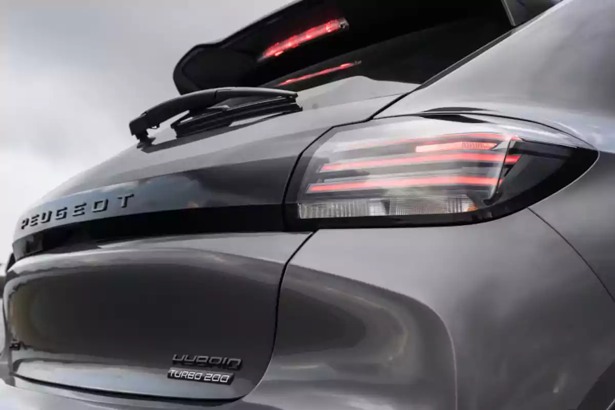 Rear of a gray Peugeot car with taillights on and visible emblems Rear of a gray Peugeot car with taillights on and visible emblems