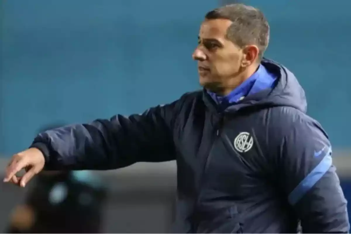 Entrenador de fútbol con campera azul de San Lorenzo dando indicaciones en un partido Entrenador de fútbol con campera azul de San Lorenzo dando indicaciones en un partido