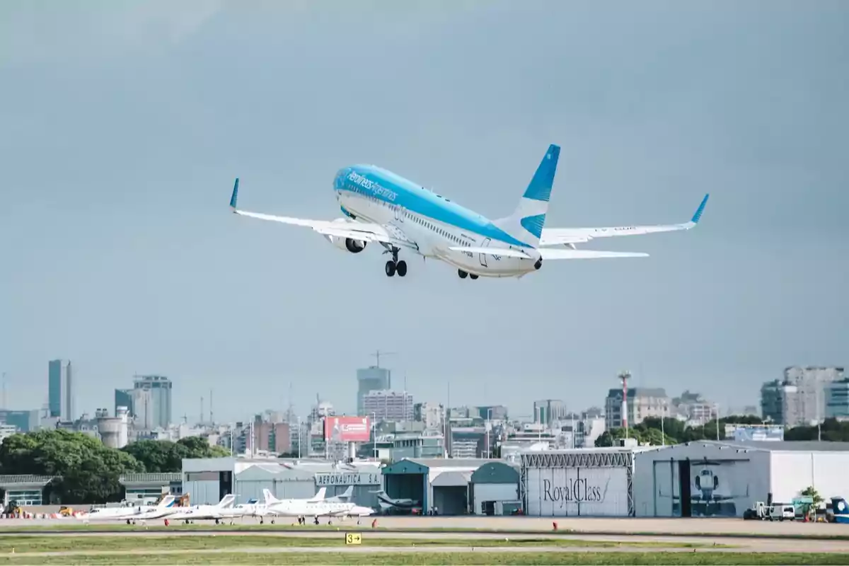 Aerolíneas Argentinas plane taking off from an airport with the city in the background