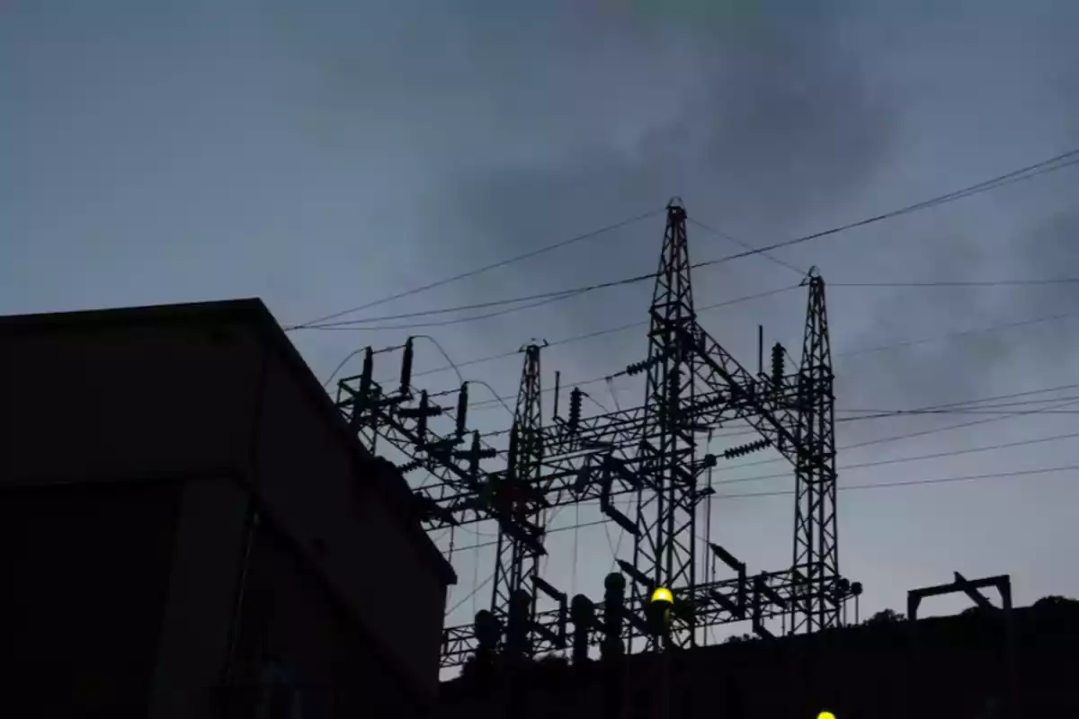 Electric substation structure at sunset with cables and a cloudy sky in the background