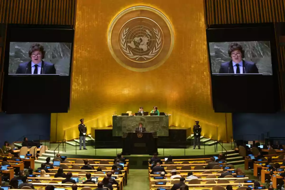 A speaker delivers a speech at the main podium of the United Nations General Assembly while attendees watch from their seats.