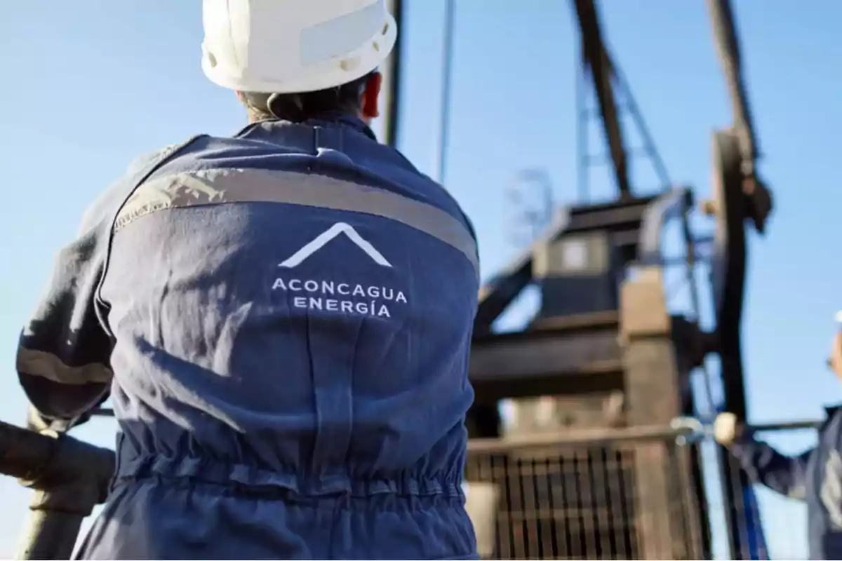 Trabajador con casco y uniforme de Aconcagua Energía en un sitio industrial al aire libre Trabajador con casco y uniforme de Aconcagua Energía en un sitio industrial al aire libre