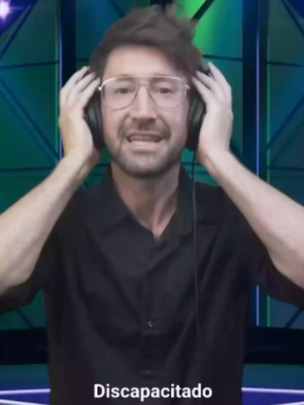 Man with black glasses and headphones speaking in front of a colorful background with the word Man with black glasses and headphones speaking in front of a colorful background with the word