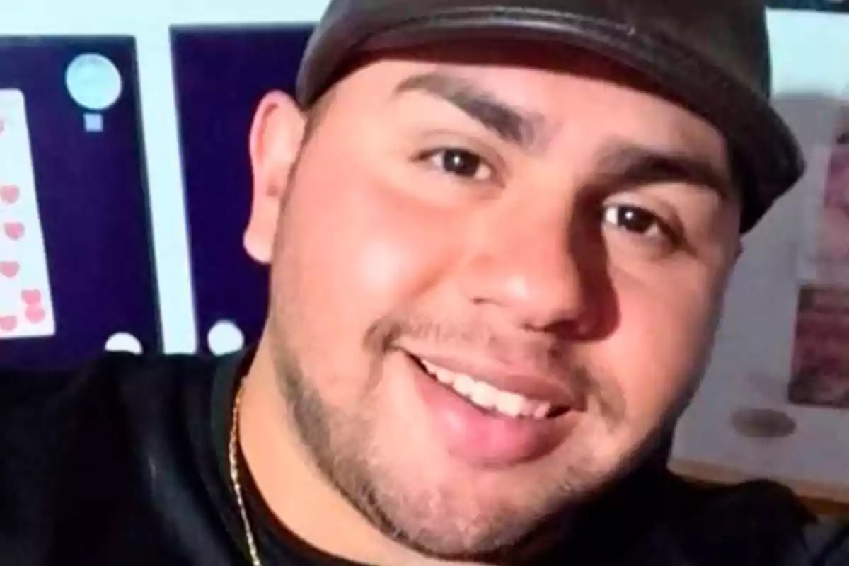 Hombre joven con barba corta y gorra negra sonriendo frente a la cámara