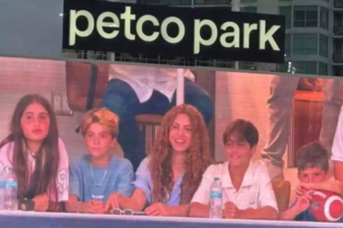 Grupo de personas sentadas en una mesa en un estadio con el letrero de petco park arriba Grupo de personas sentadas en una mesa en un estadio con el letrero de petco park arriba