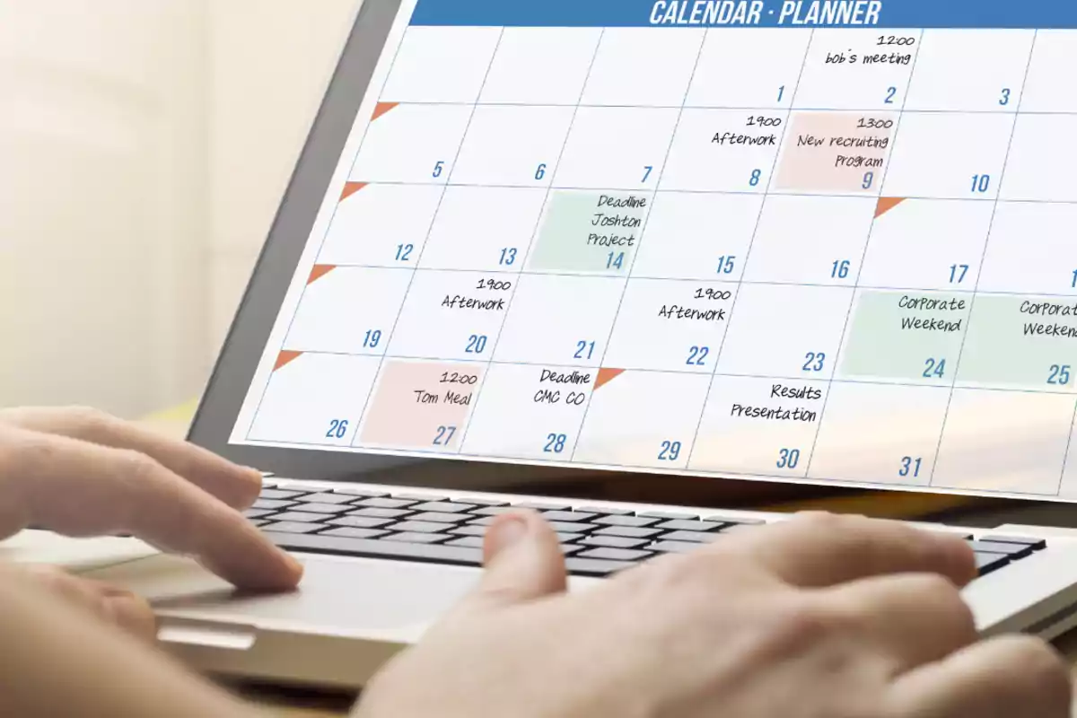 Person using a laptop with a digital calendar on the screen displaying events and reminders written on different days of the month