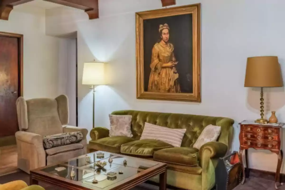 Vintage-style room with a green sofa, beige armchair, glass coffee table, lamps, and an antique painting on the wall Vintage-style room with a green sofa, beige armchair, glass coffee table, lamps, and an antique painting on the wall