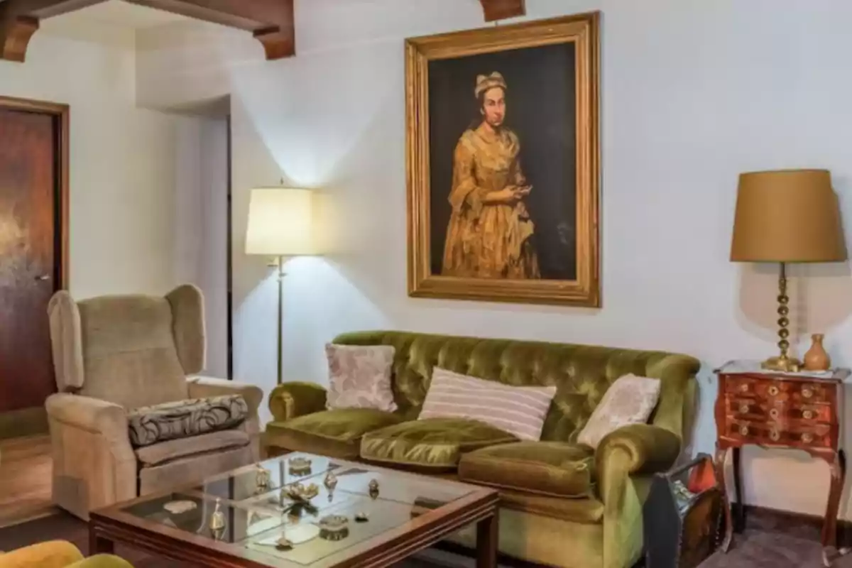 Vintage-style room with a green sofa, beige armchair, glass coffee table, floor and table lamps, and an antique painting of a woman on the wall. Vintage-style room with a green sofa, beige armchair, glass coffee table, floor and table lamps, and an antique painting of a woman on the wall.